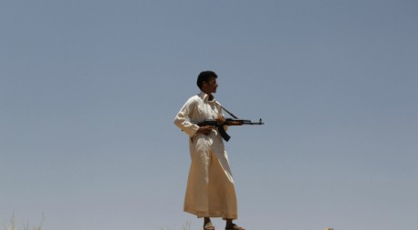 Un rebelle libyen scrute au loin les combats, Al Qawalish, à 100km de la capitaleTripoli, 13 juillet 2011. REUTERS/Ammar Awad