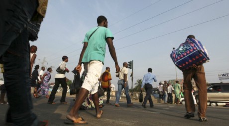 Badauds traversant la rue à Abidjan, 22 décembre 2010, REUTERS/Luc Gnago