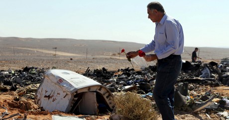 Un homme pose des fleurs sur les débris de l'Airbus A321 qui s'est crashé dans le Sinaï. Photo: REUTERS/Mohamed Abd El Ghany