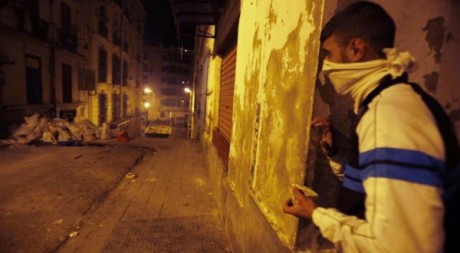 Un jeune Algérien tient une pierre durant les affrontements avec la police à Alger, dans le quartier de Bab el-Oued, le 6 janvie