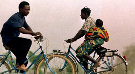 Une femme part au travail à vélo avec son bébé, à Ouagadougou, Burkina Faso. REUTERS/Juda Ngwenya