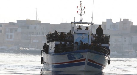 Des immigrés clandestins tunisiens arrivent sur l'île italienne de Lampedusa, le 13 février 2011. REUTERS/Antonio Parrinello