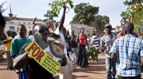 Un opposant mange un poster à l'effigie d'un candidat pro-Museveni, en Ouganda. © Ines Della Valle, tous droits réservés.