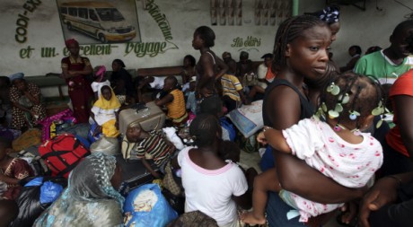 Des Ivoiriens attendent le bus à Abidjan pour fuir vers la campagne, le 20 mars 2011. REUTERS/Luc Gnago