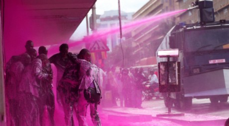 La police a aspergé d'eau colorée rose les leaders de l'opposition, le 10 mai à Kampala. REUTERS/James Akena
