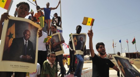 Des habitants de Benghazi brandissent des posters d'Abdoulaye Wade lors de sa visite, le 9 juin 2011. REUTERS/STR New