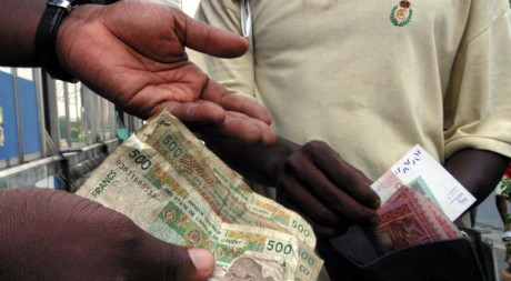Des Africains échangent des francs CFA, en décembre 2004. REUTERS/Thierry Gouegnon