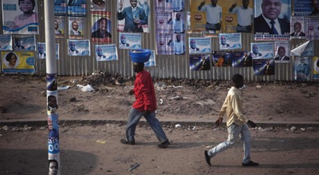 Des Congolais marchent devant des panneaux électoraux à Kinshasa, le 25 novembre 2011. REUTERS/Finbarr O'Reilly