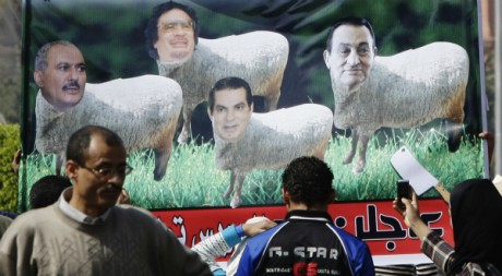 Des Egyptiens regardent une pancarte représentant les dictateurs arabes. REUTERS/Mohamed Abd El Ghany