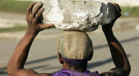Un ouvrier ramasse des gros blocs de pierre sur l'île de Cuba, 17 décembre 2009. Reuters/Desmond Boylan