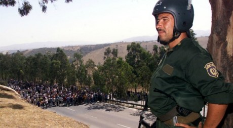 Un policier regarde la manifestation pacifique de jeunes berbères sur une route à l’est d’Alger, le 8 août 2001. REUTERS/StrOld