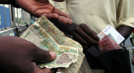 Deux hommes échangent de l'argent à Abidjan, 31/12/2004, REUTERS/Thierry Gouegnon
