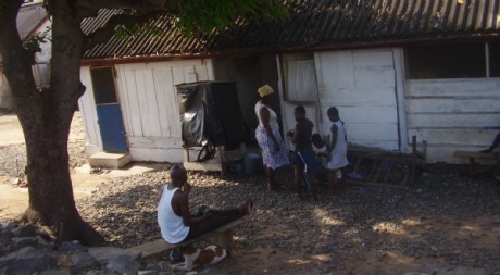 Le fils ainé d'Adjo écoutant la radio pendant que sa mère s'occupe de ses petits enfants © Bruno Sanogo, tous droits réservés