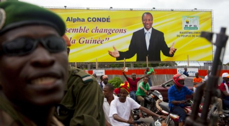Un gendarme devant une affiche électorale du candidat Alpha Condé, à Conakry 19 octobre 2010, REUTERS/Stringer