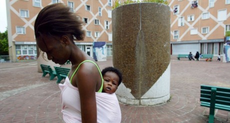 Une femme avec son enfant, à Grigny, le 15 juillet 2002. JOEL ROBINE / AFP