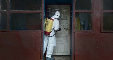Un agent de santé décontamine une poignée de porte , Monrovia. © Kieran Kesner via Mashable