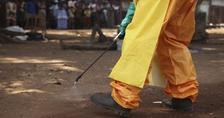 Un membre de la Croix-Rouge désinfecte une zone contaminée, le 30 janvier 2015 en Guinée. REUTERS/Misha Hussain