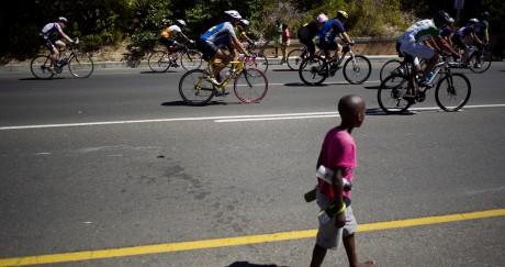 Un enfant marche près du peloton du Tour du Cap, en Afrique du Sud. RODGERBOSCH / AFP