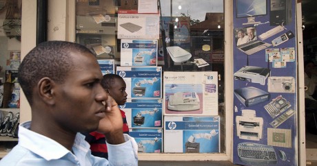 Un homme au téléphone devant un magasin hi-tech à Kampala, le 11 novembre 2011. MICHELE SIBILONI / AFP
