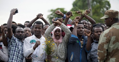 Des membres de l'ethnie oromo font le signe de croix au dessus de leur tête, le 2 octobre à Bishoftu. Zacharias ABUBEKER / AFP